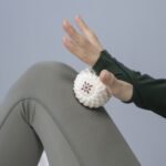 Bloom white massage ball under a hand